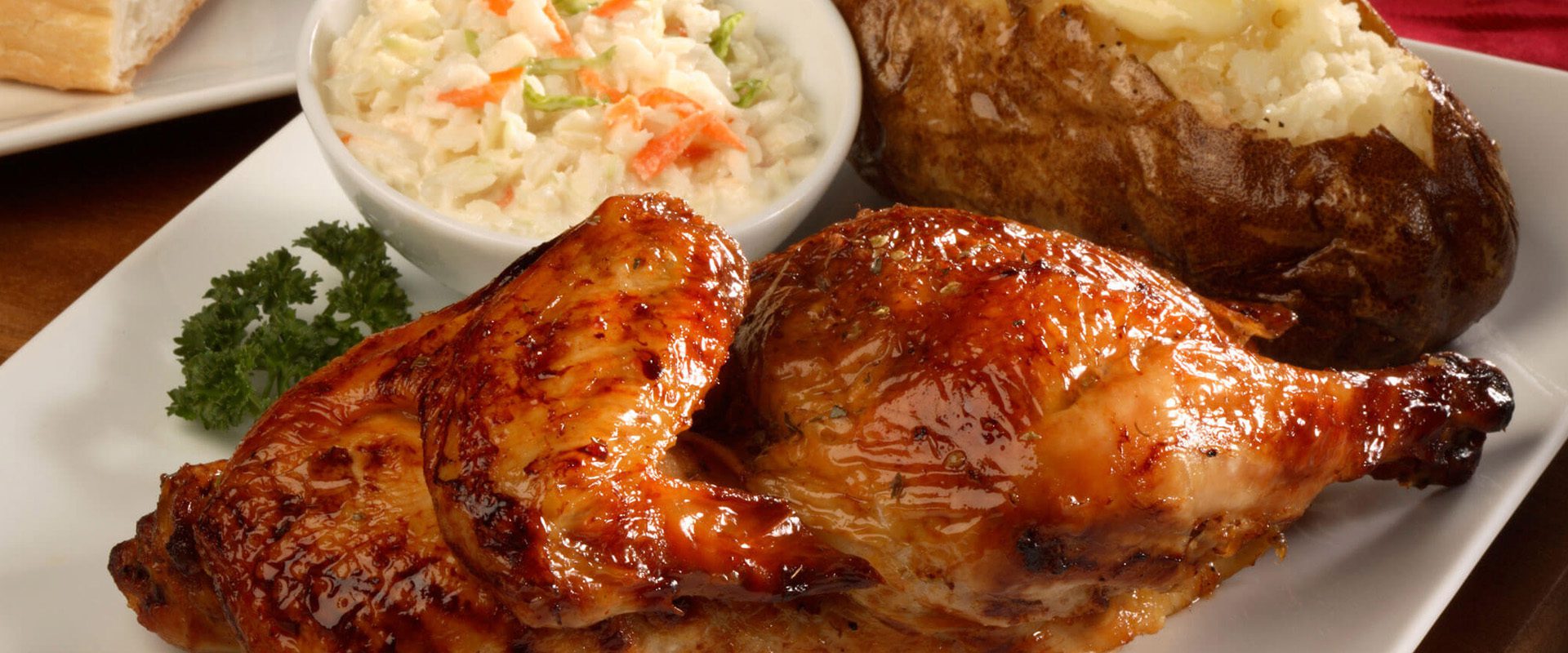 Rotisserie Chicken Dinner dish with a hot potato and salad on the side.